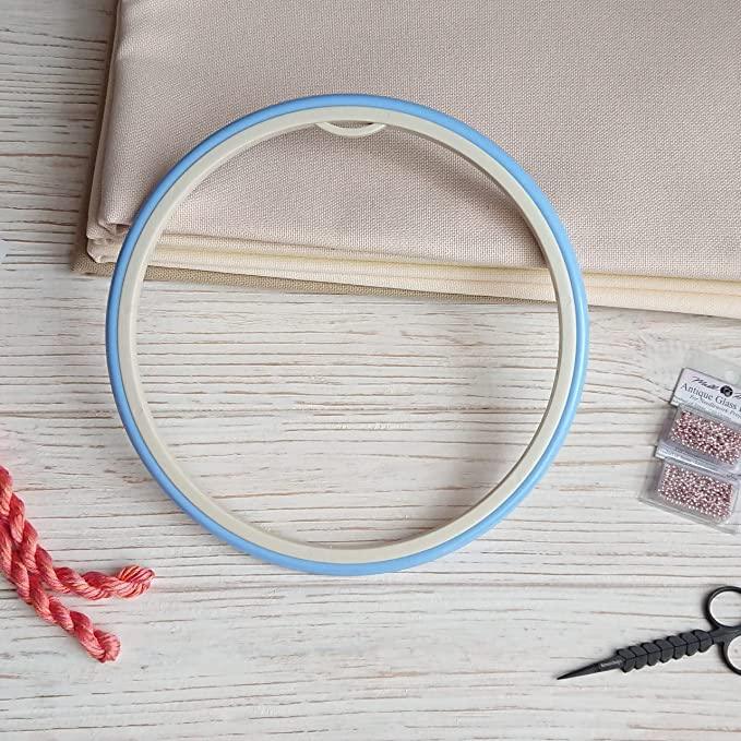 Plastic embroidery hoop with flexible rubbery ring.
